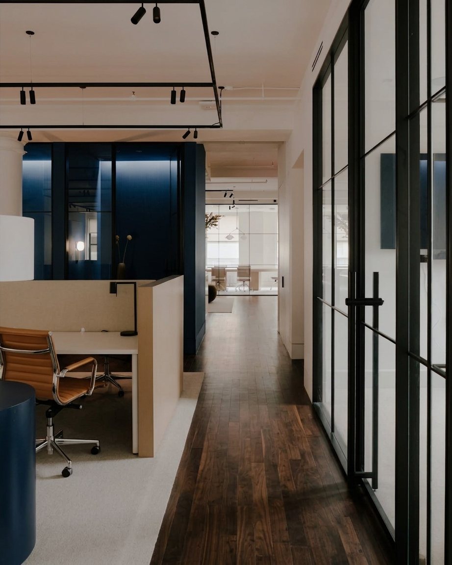Modern office with glass walls and a wood-floor hallway